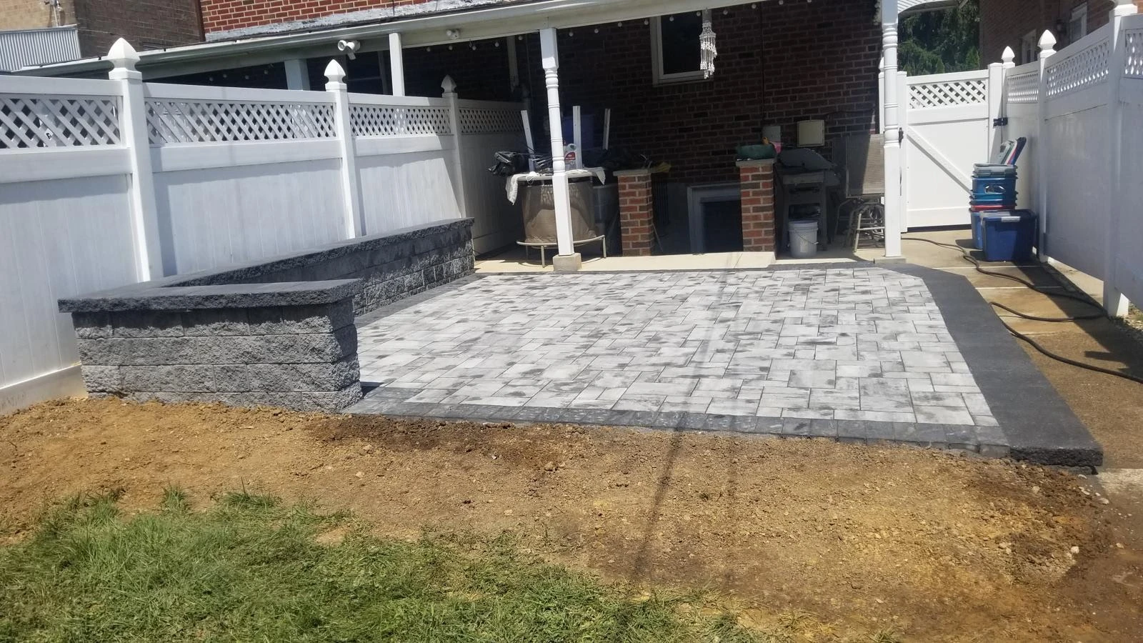 Paver patio surrounded by raised masonry borders